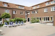 Blick auf den Innenhof mit Liegen der Kurklinik "Haus am Deich" in Norddeich direkt an der Nordsee